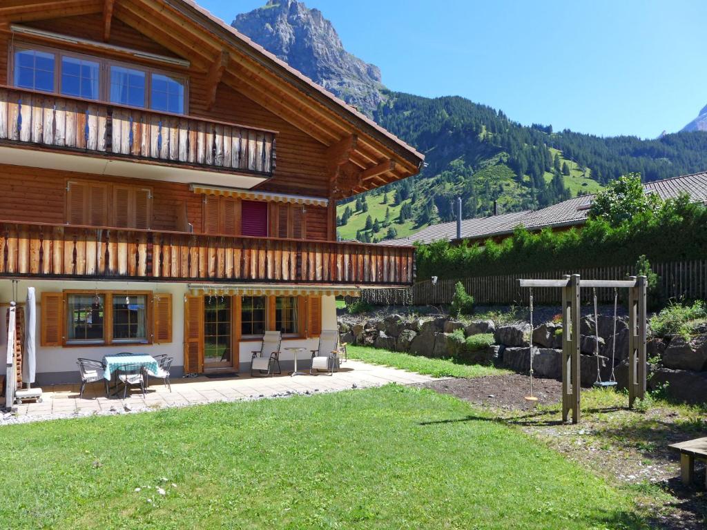 une maison dans les montagnes avec une cour dans l'établissement Apartment Laerchehus Ost by Interhome, à Kandersteg