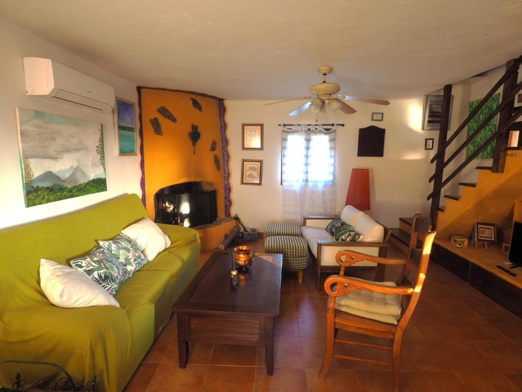 a living room with a green couch and a table at LOS TASAJILLOS, Vivienda de uso Turístico in Candeleda