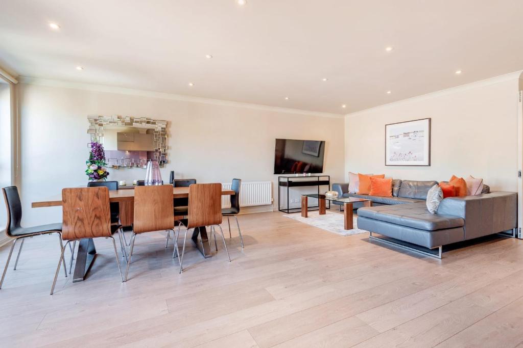 - un salon avec une table et un canapé dans l'établissement Stunning 3-bedroom in the heart of London with parking-hosted by Sweetstay, à Londres