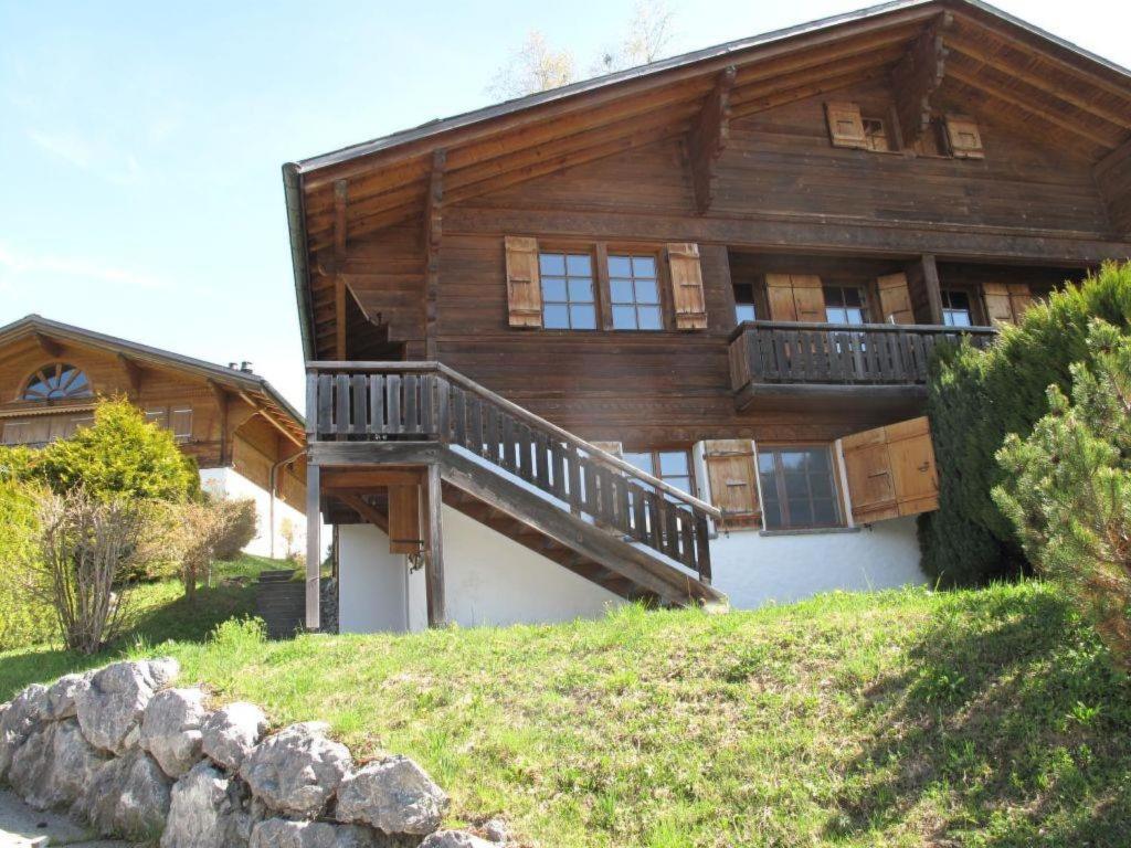 ein großes Holzhaus mit Balkon auf einem Hügel in der Unterkunft Apartment Les Hivernants - EG links by Interhome in Gstaad