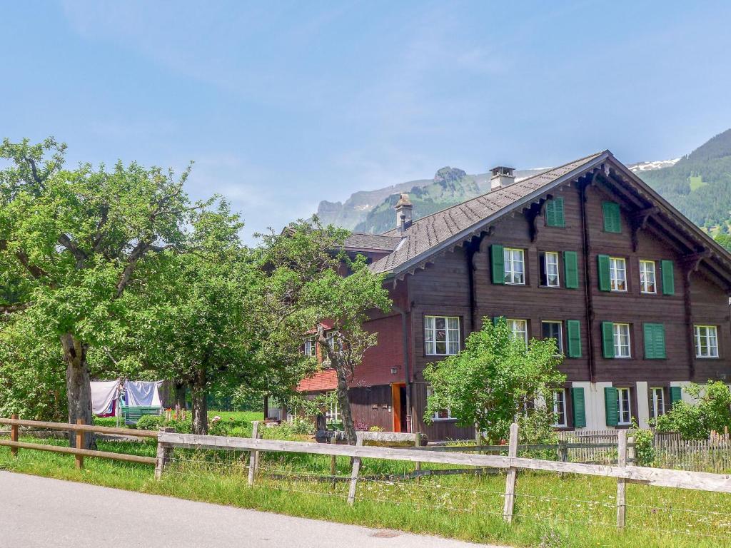 a large wooden house with a fence in front of it at Apartment Chalet Chilchboden by Interhome in Grindelwald