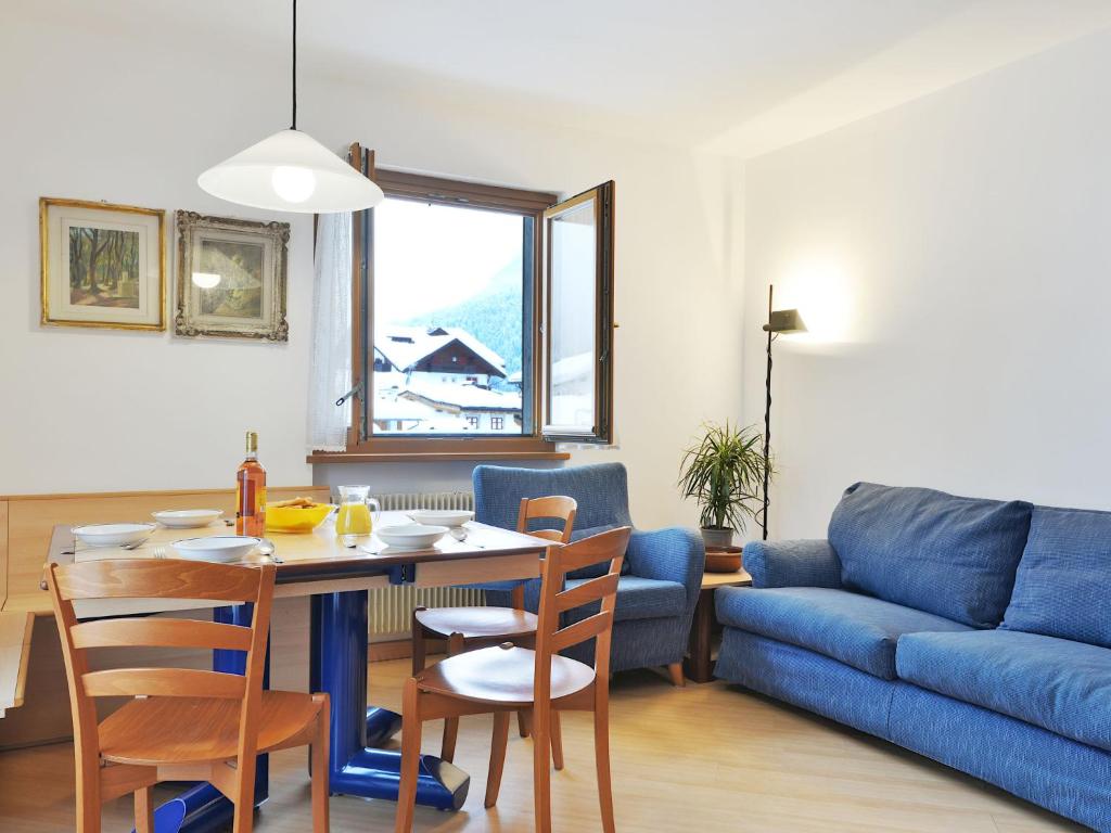 een woonkamer met een tafel en een blauwe bank bij Apartment Al Parco-3 by Interhome in Canazei