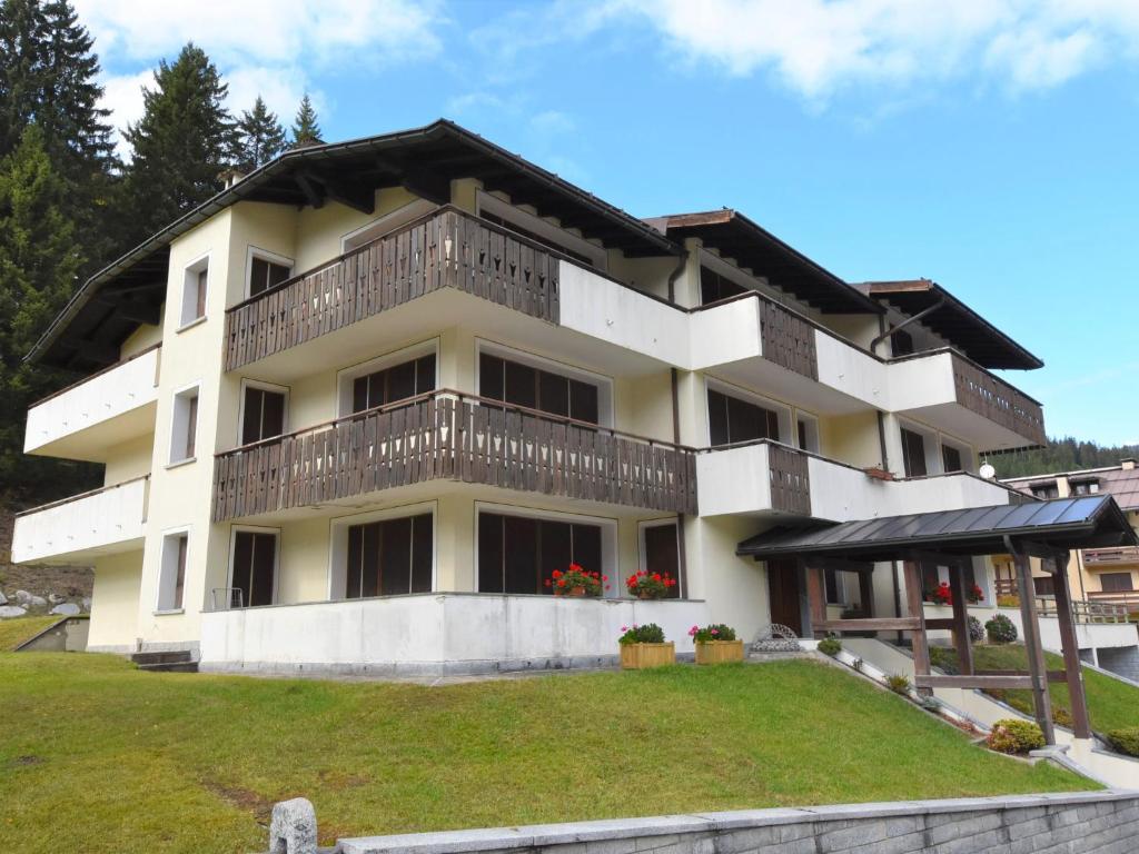 a white building with a balcony and a yard at Apartment Frassan Apartments-1 by Interhome in Madonna di Campiglio