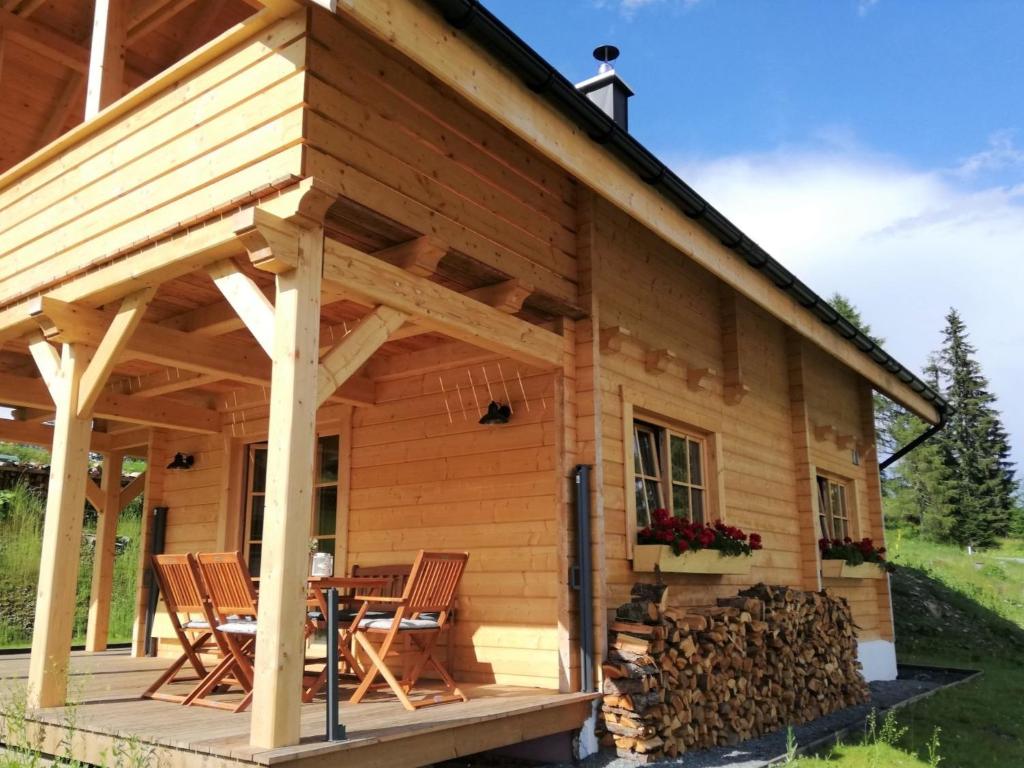 eine Blockhütte mit Stühlen und einem Tisch in der Unterkunft Chalet Buchfink by Interhome in Hochrindl