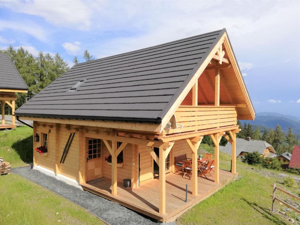 a large wooden cabin with a black roof at Chalet Hütte Gimpel by Interhome in Hochrindl