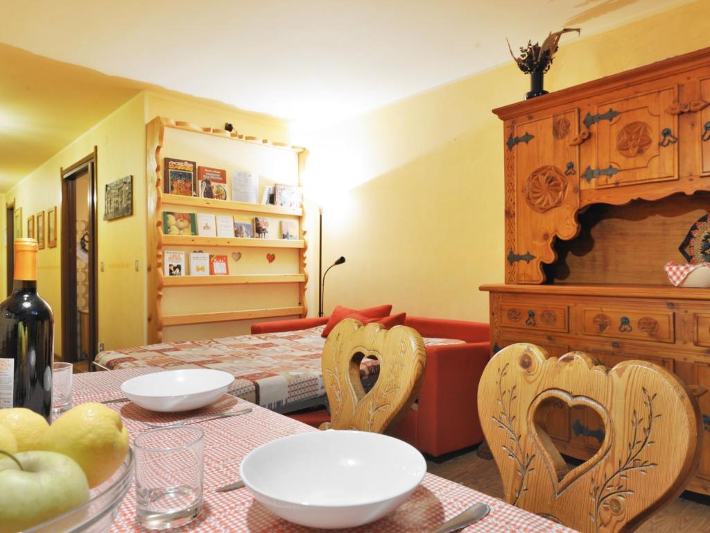 uma sala de jantar com uma mesa com corações esculpidos em cadeiras em Apartment Enrosadira-3 by Interhome em Alba di Canazei