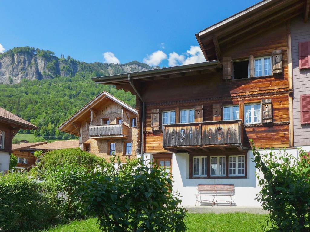 ein Holzhaus mit einem Balkon und Bergen im Hintergrund in der Unterkunft Holiday Home Chalet Esther by Interhome in Brienz