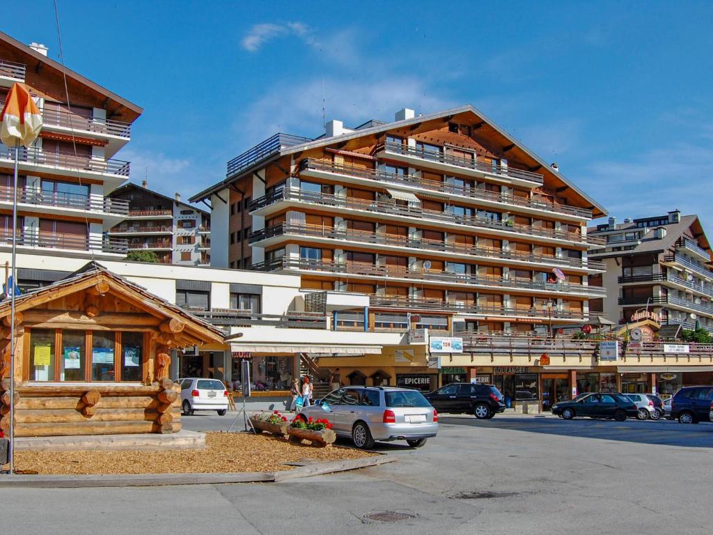 a large building with cars parked in a parking lot at Studio Bouleaux B1 by Interhome in Nendaz