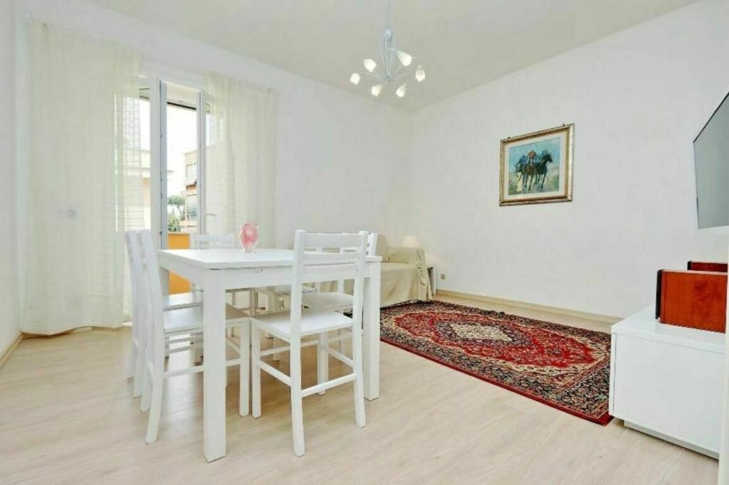 a white dining room with a white table and chairs at Balestra in Rome