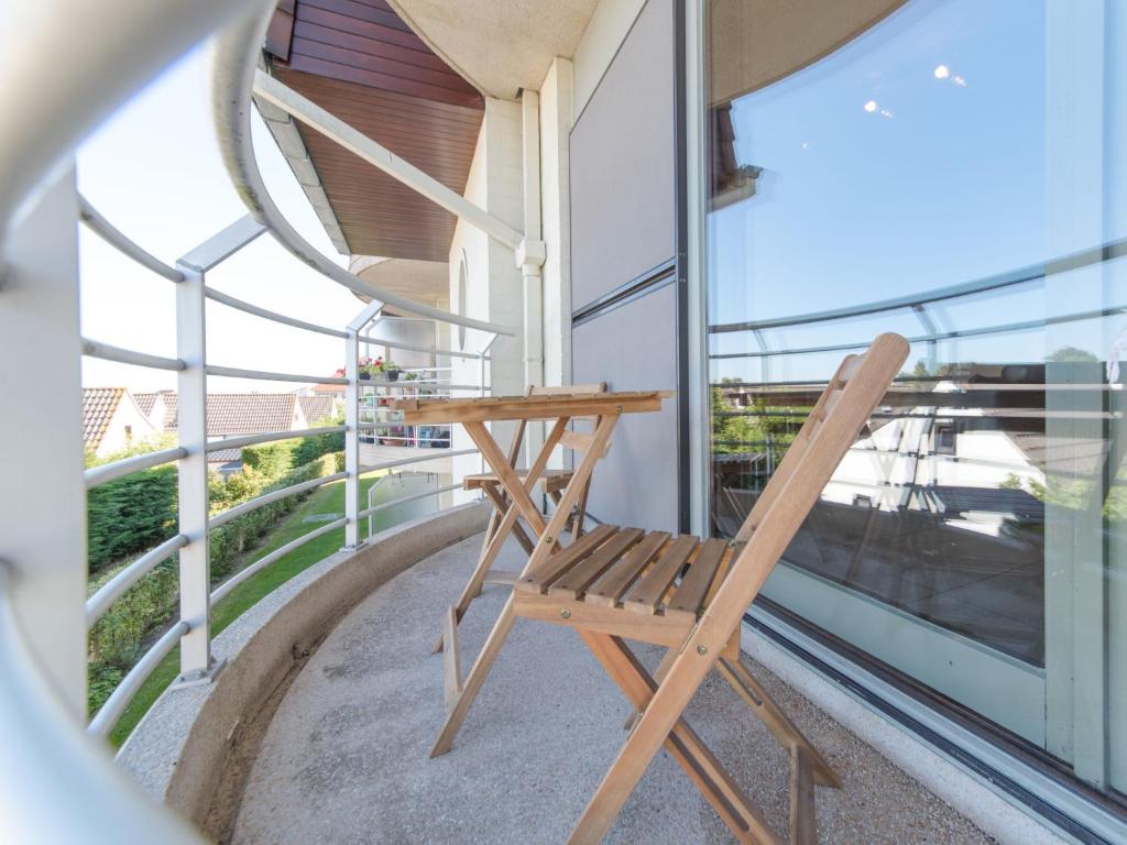 a wooden chair sitting on the balcony of a building at Apartment Firenze 108 with parking by Interhome in Bredene