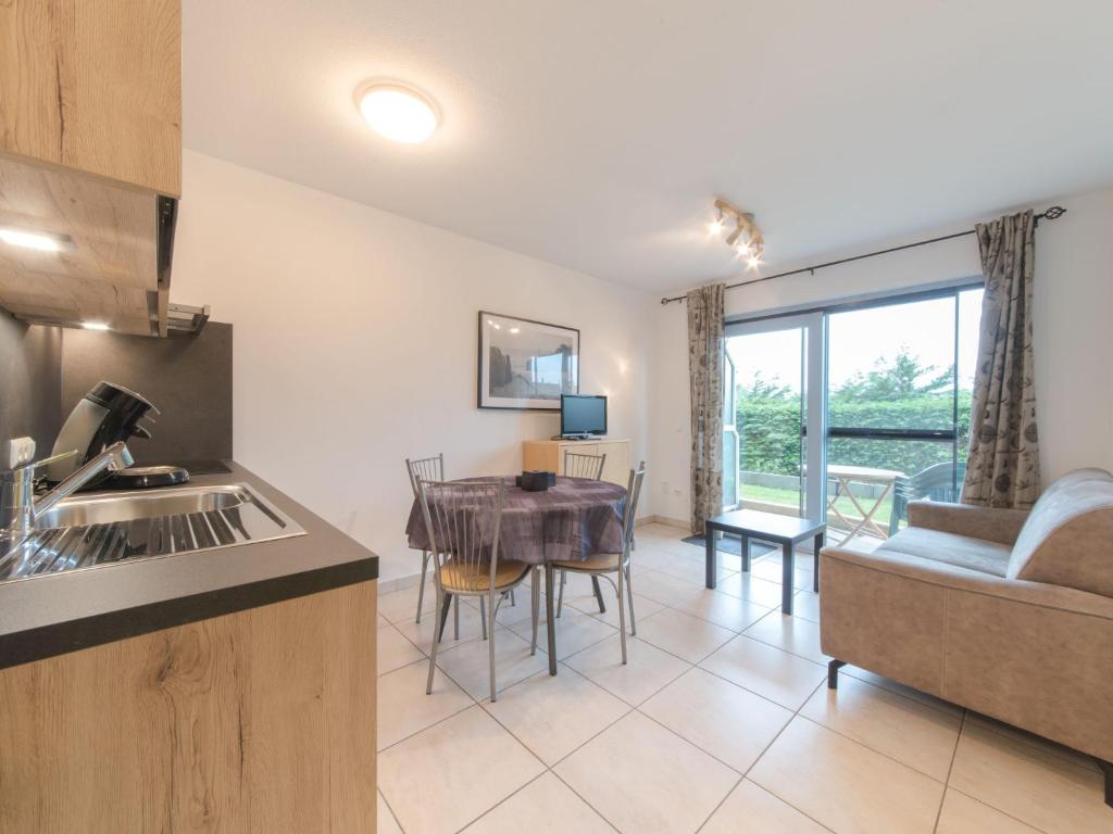 a kitchen and living room with a table and a couch at Studio Deauville II 010 with parking by Interhome in Bredene