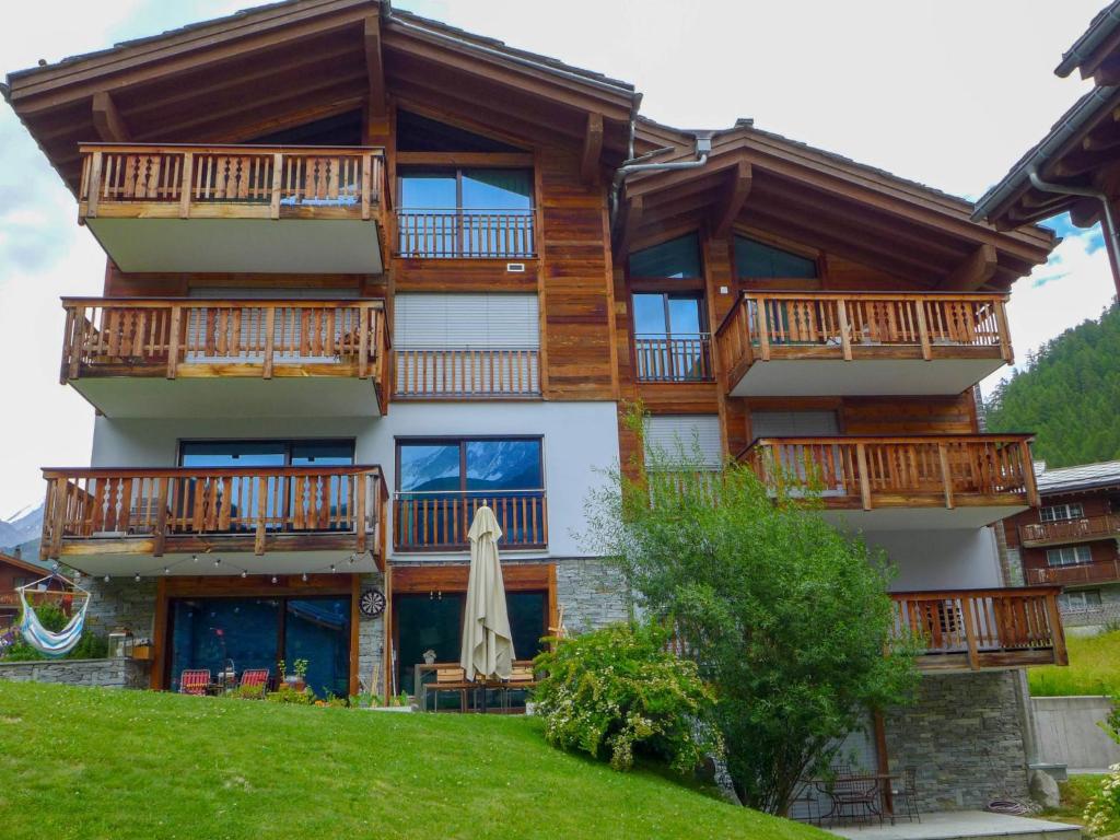 un immeuble d'appartements avec balcon et parasol dans l'établissement Apartment Dione by Interhome, à Zermatt