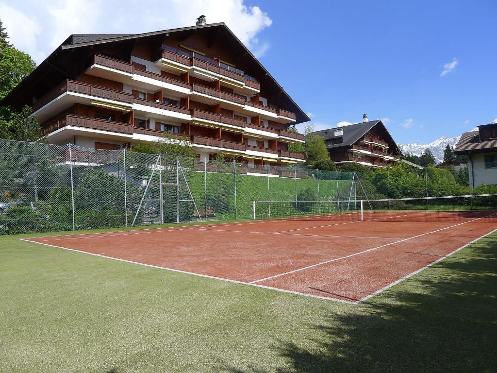 einen Tennisplatz vor einem Gebäude in der Unterkunft Apartment Grand Hôtel A10 by Interhome in Villars-sur-Ollon