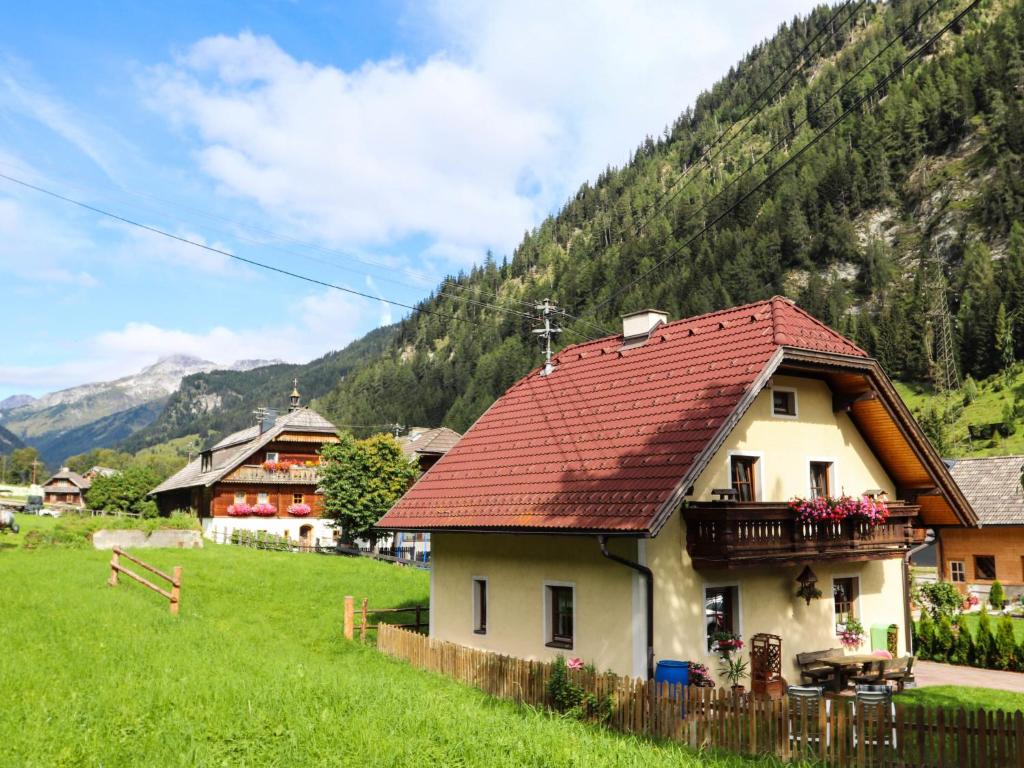 a house with a red roof on a green field at Holiday Home Gebhardt by Interhome in Zederhaus