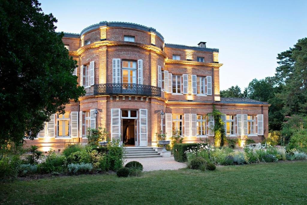 uma grande casa de tijolos com uma escada em frente em Château de Roquefoulet Luxury Guesthouse & Spa - Teritoria em Montgeard