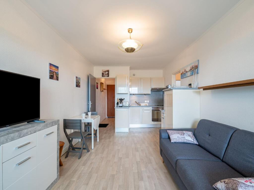 ein Wohnzimmer mit einem Sofa und einer Küche in der Unterkunft Apartment Plein Sud by Interhome in Cabourg