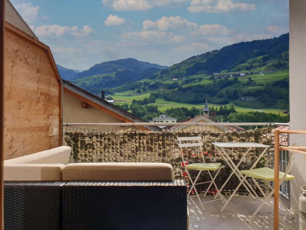 a balcony with a couch and a table and chairs at Apartment Tga da Plaz by Interhome in Zillis