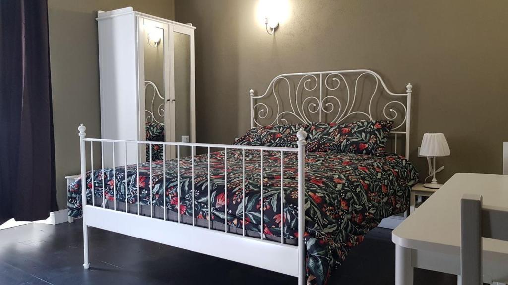 a bedroom with a white bed with a floral bedspread at The Green Lake House in Lenna