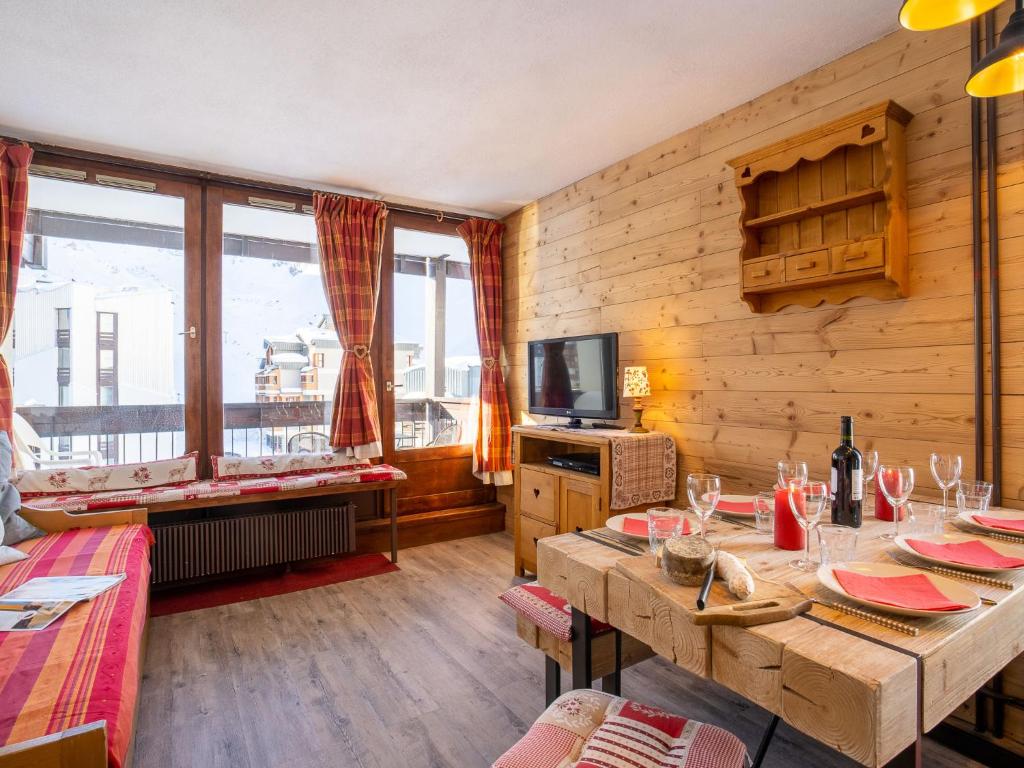 Cette chambre dispose de murs en bois, de tables et d'une télévision. dans l'établissement Apartment Le Prariond - Val Claret-12 by Interhome, à Tignes