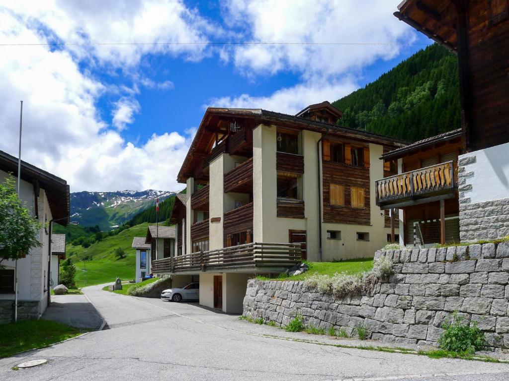 ein großes Gebäude mit einer Steinmauer neben einer Straße in der Unterkunft Apartment Casa Alpetta by Interhome 