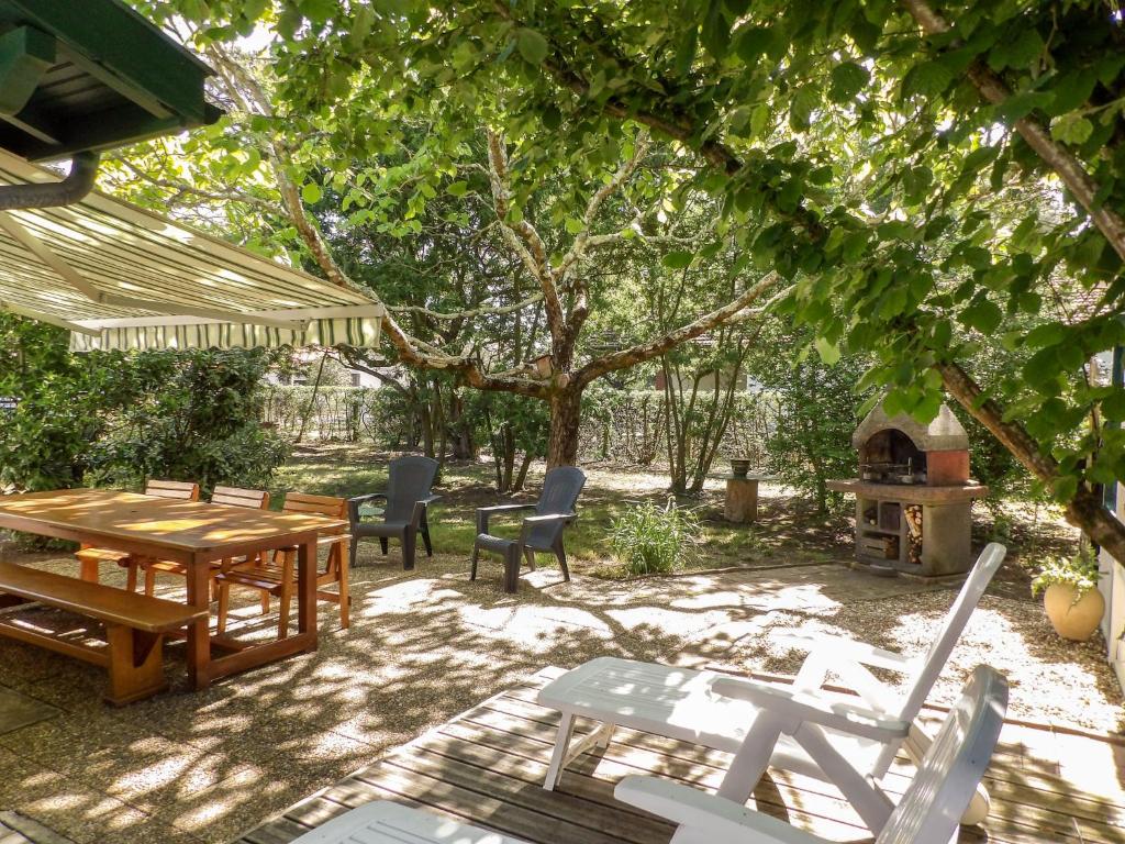 d'une terrasse avec une table, des chaises et un poêle à bois. dans l'établissement Holiday Home Pignada by Interhome, à Mimizan