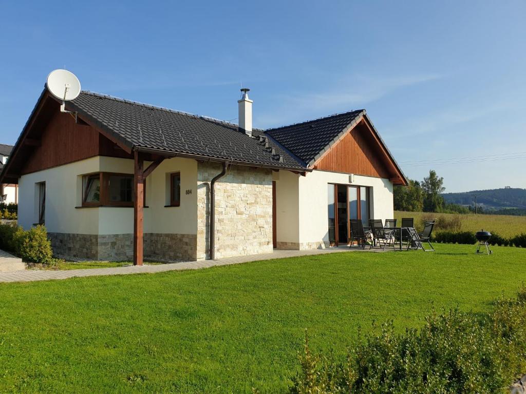 a house with a green lawn in front of it at Holiday Home Residence Lipno by Interhome in Lipno nad Vltavou