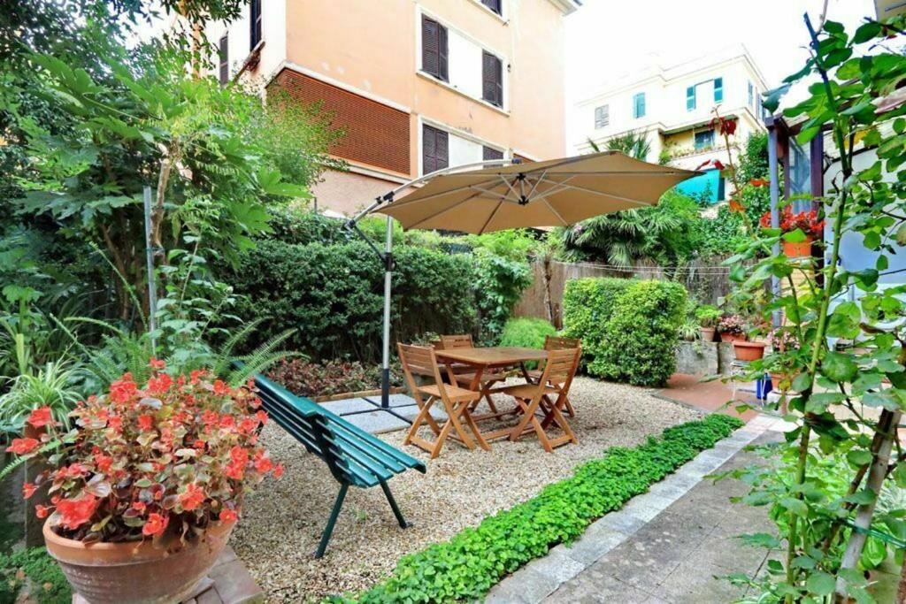 a garden with a table and a bench and an umbrella at Clodia in Rome