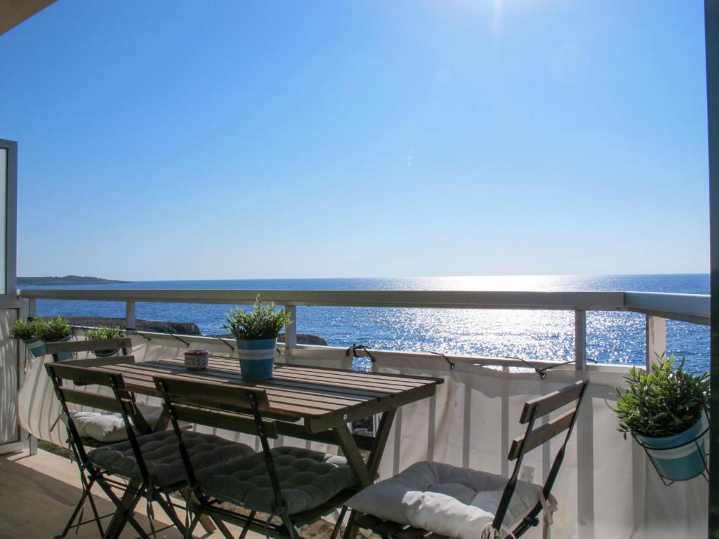een tafel en stoelen op een balkon met uitzicht op de oceaan bij Apartment Apartment S'Illot-Cala Morlanda by Interhome in S'Illot