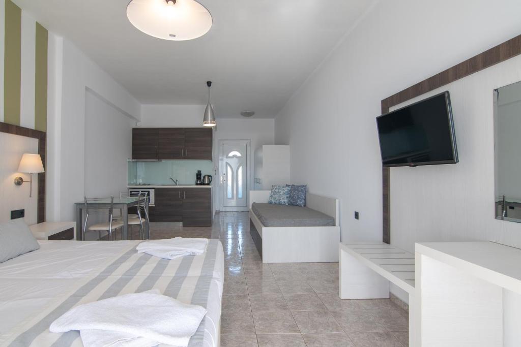 a living room with a bed and a kitchen at Mythos Apartments in Damnoni