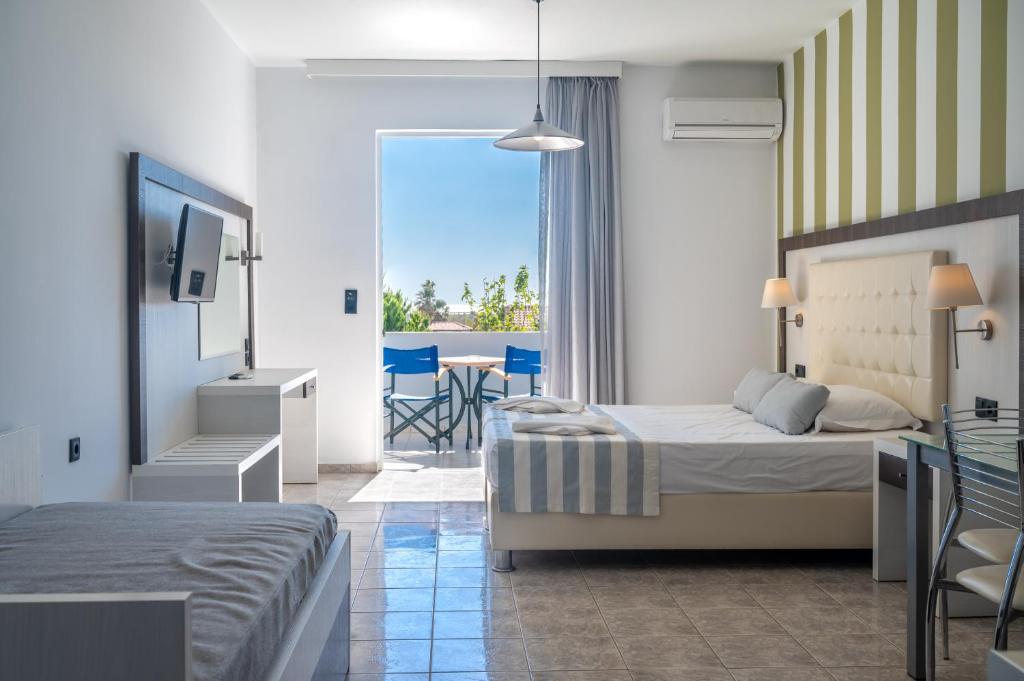 a hotel room with two beds and a balcony at Mythos Apartments in Damnoni