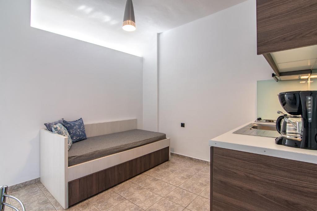 a kitchen with a bench in the corner of a room at Mythos Apartments in Damnoni