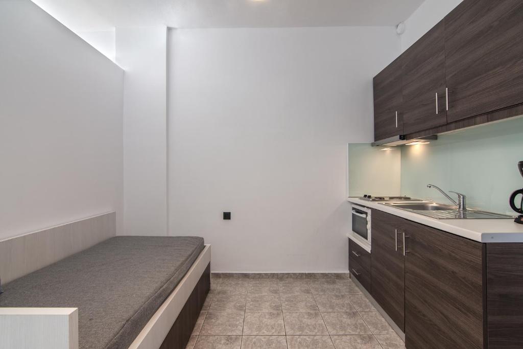 a kitchen with a bed in the middle of it at Mythos Apartments in Damnoni