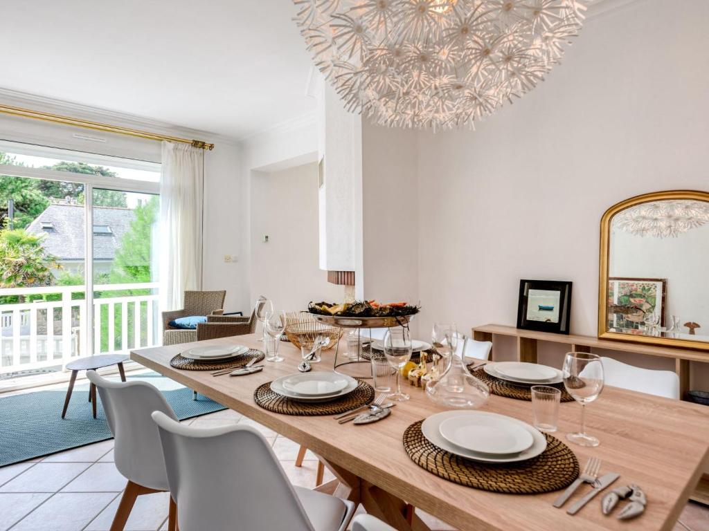 a dining room with a wooden table and chairs at Holiday Home Rayon de soleil by Interhome in Carnac