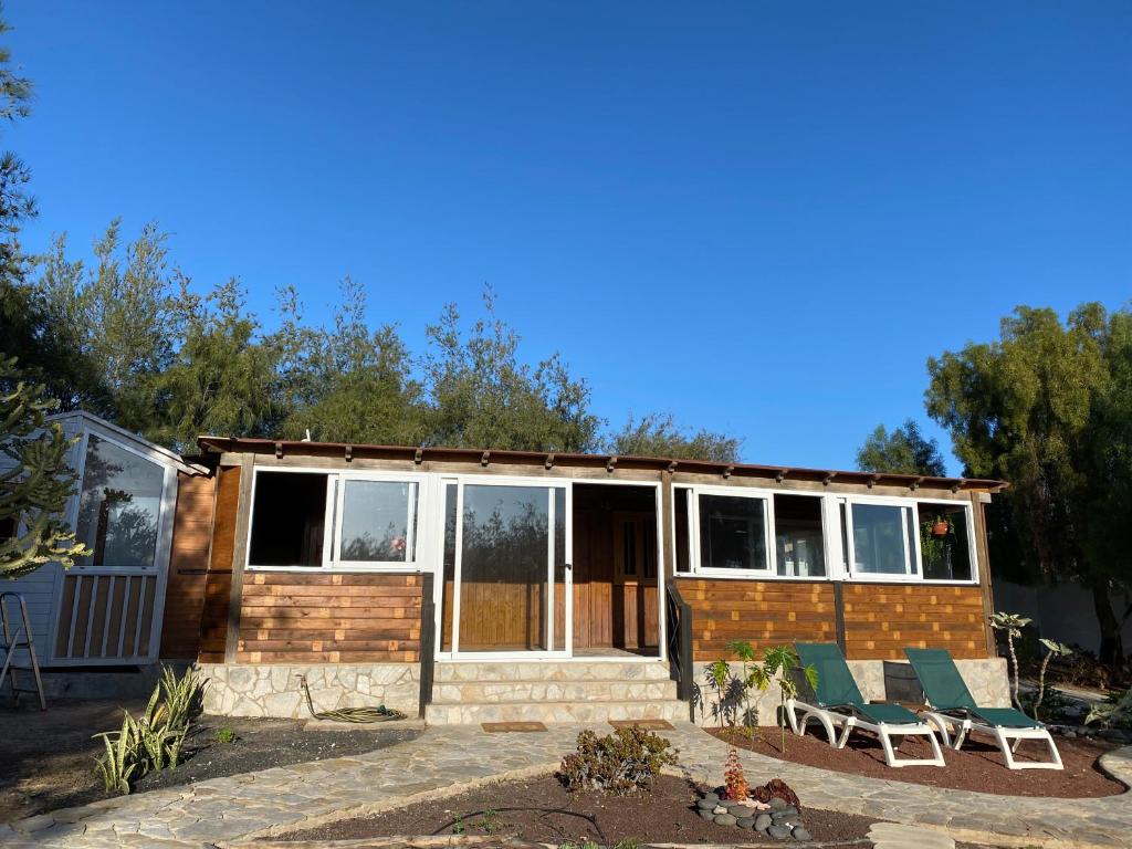 a small house with two chairs and a porch at Fuerte Action Guest House in Costa Calma