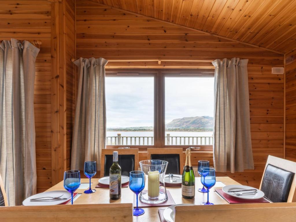 a dining room with a table with wine glasses at Chalet Loch Leven Lodge 12 by Interhome in Kinross