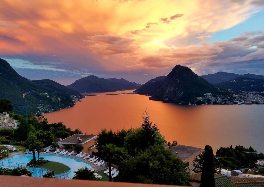 Blick auf einen großen Wasserkörper mit Bergen in der Unterkunft Appartamento Chicca in Lugano