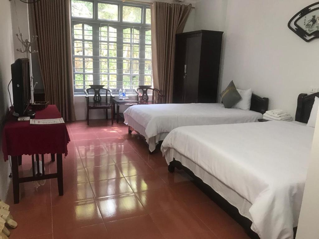 a hotel room with two beds and a television at ANH ANH HOTEL in Bắc Hà
