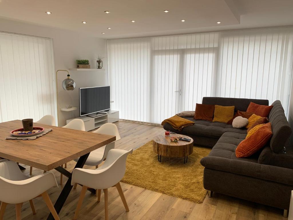 a living room with a couch and a table at La Panne Appartement en bord de mer - La Vie Bohème in De Panne