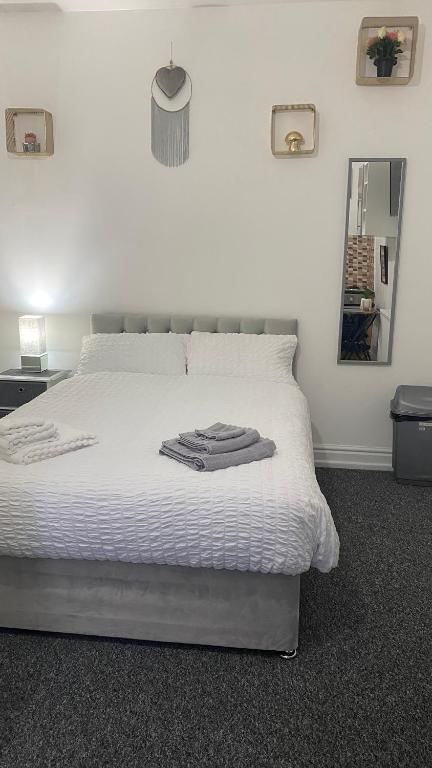 1 dormitorio con cama blanca y espejo en BVapartments-Blackhouse F2, en Huddersfield