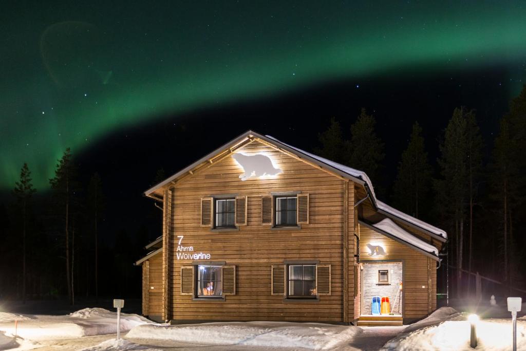 a house with the northern lights above it at night at Ranua Resort Holiday Villas in Ranua