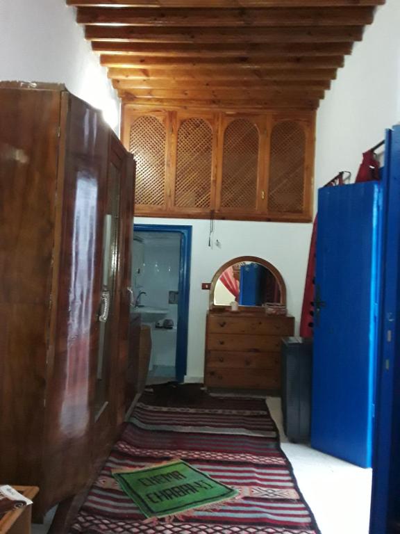 a room with blue cabinets and a rug on the floor at Maison d'hôte Chama in Kairouan
