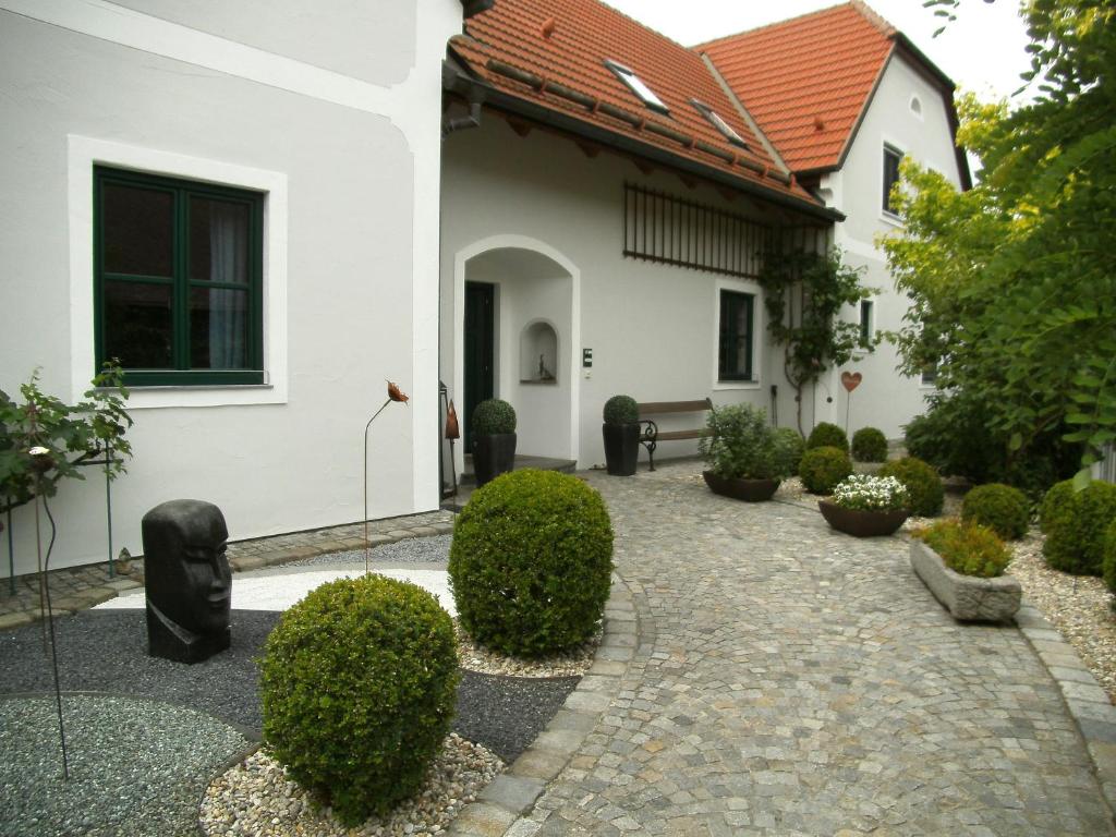 a courtyard of a white house with bushes at Landhaus Rossatz in Rossatz