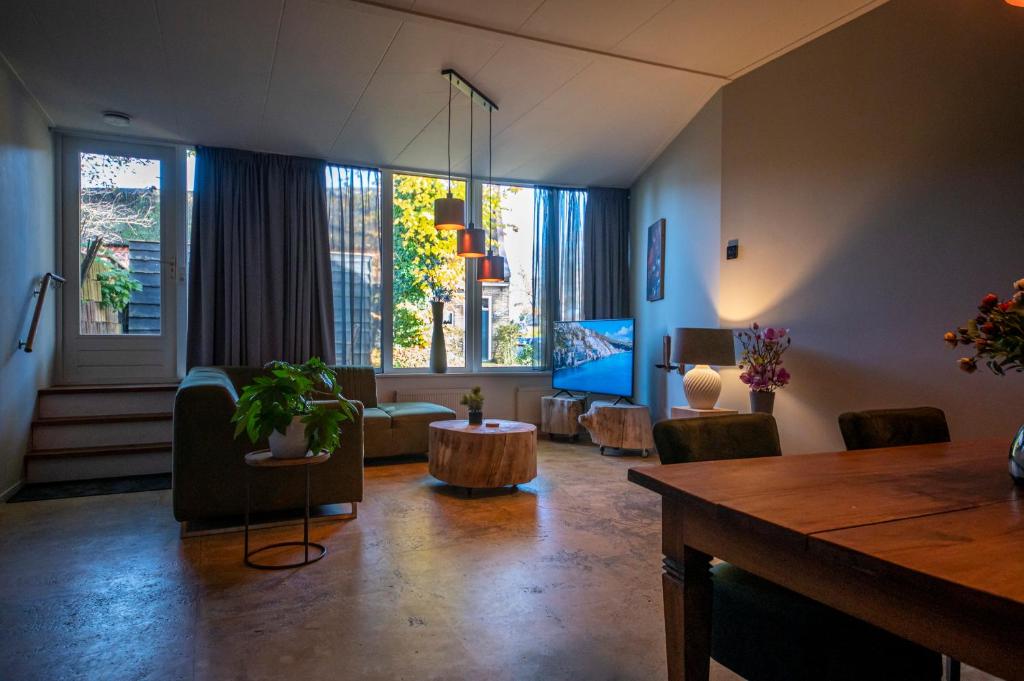 een woonkamer met een tafel en stoelen bij Brinkzicht Diever, appartement Coby in Diever