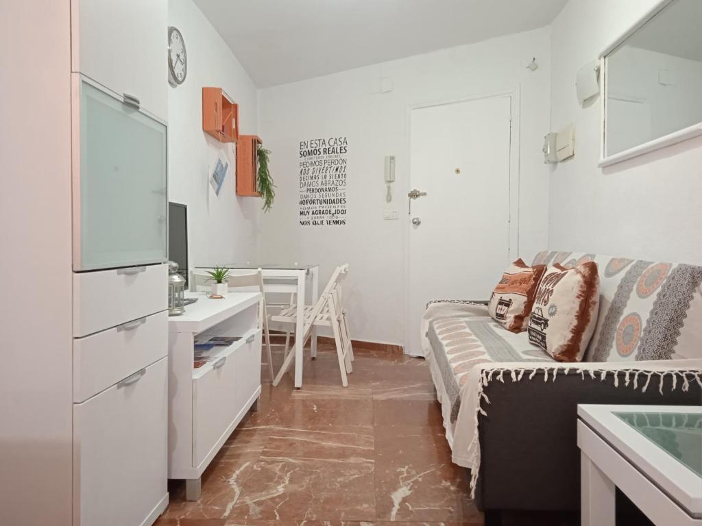 Cette petite chambre blanche dispose d'un canapé et d'un bureau. dans l'établissement Apartamento Con Encanto 'Larios Studio', à Malaga