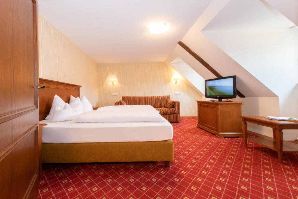 a hotel room with a bed and a television at Brauerei-Gasthof Hotel Post in Nesselwang