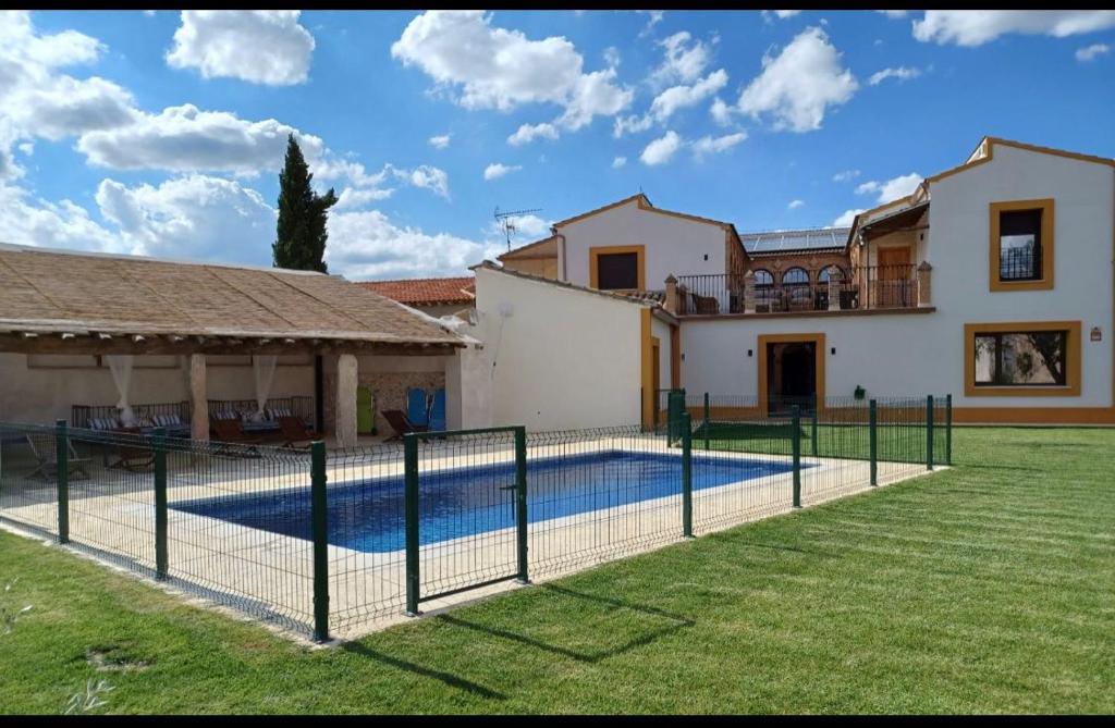 a villa with a swimming pool in front of a house at Casa Rural de Ancos, Guadamur, Toledo in Guadamur