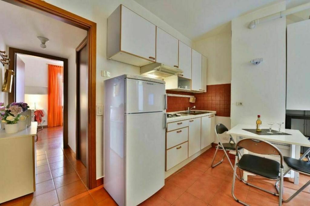 een keuken met een witte koelkast en een tafel bij Como in Milaan