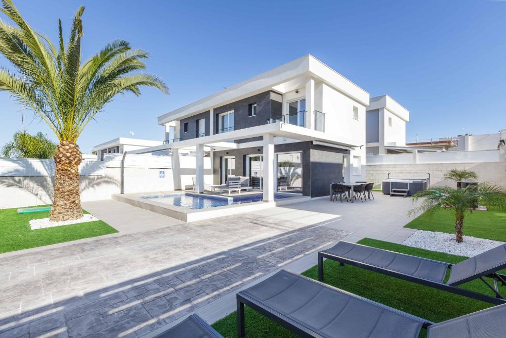 a villa with a swimming pool and palm trees at Casa Bos Dolpfin Wellness Luxury Entire Villa Pool & Jacuzzi Gran Alacant near Beach in Puerto Marino