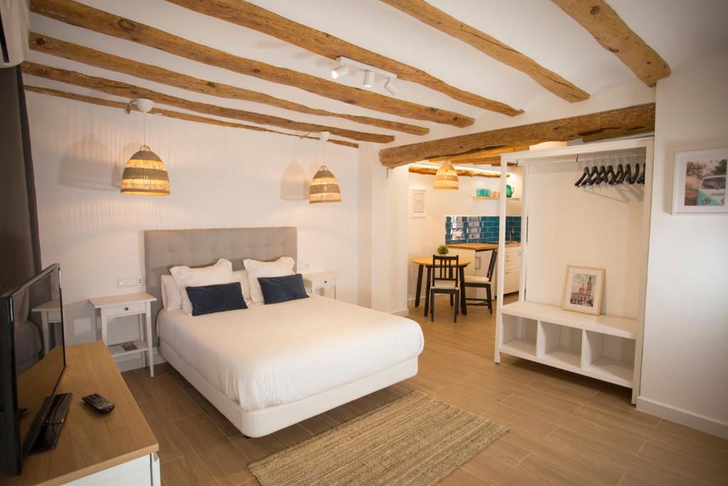 a bedroom with a white bed and a dining room at Savoy in Alcoy