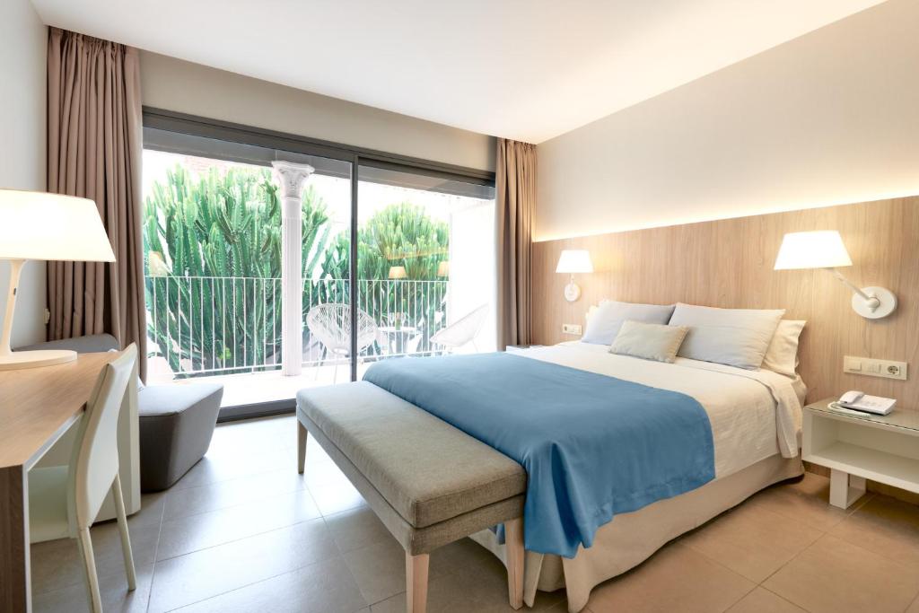 a bedroom with a large bed and a large window at Hotel Omnium in Barcelona